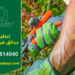 عامل من شركة تنظيف حدائق في العين يقوم بتقليم وتنظيف أحد الأشجار في حديقة منزل.