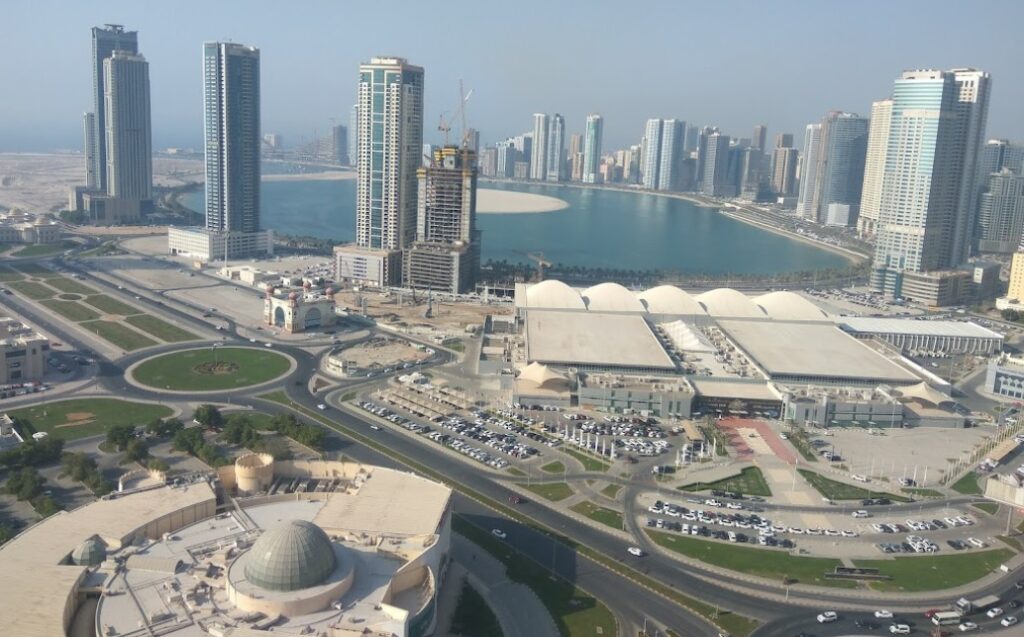 صورة من منطقة بر دبي تُظهر مزيجاً من المباني التراثية والأسواق الشعبية مع الأبراج الحديثة والشوارع المنظمة.