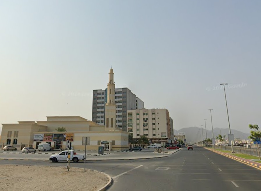 صورة من منطقة مربح تُظهر المباني السكنية المنظمة والشوارع الواسعة مع إطلالة على البحر والطبيعة المحيطة.